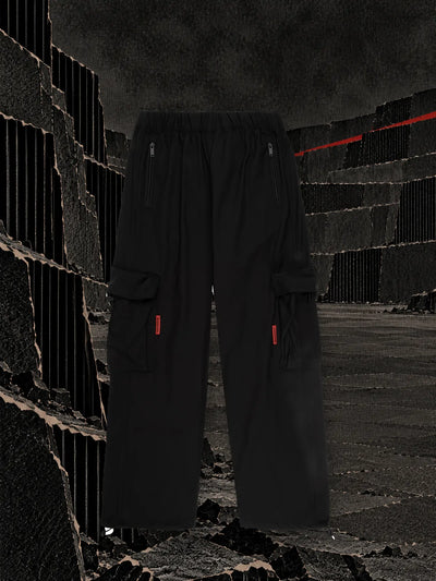 I pantaloni cargo neri in una cava a gradoni di cartone nero ondulato, con una striscia di nastro rosso sul bordo in alto.