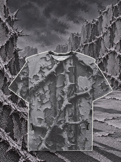 The grey Bloodrose Dark t-shirt, with a pale paper border, among walls of grey brambles in relief.