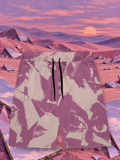 The purple BrokenEyes bermuda shorts on dunes of pink and purple paper, among the shards of a broken paper mirror.