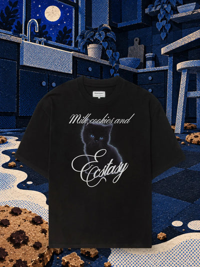 The black Ecstasy Milk t-shirt in a night kitchen of blue paper, with a river of white paper milk and scattered paper biscuits.