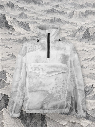 L'anorak grigio Grey Noise sopra un mare di montagne di carta grigia e bianca a retino.