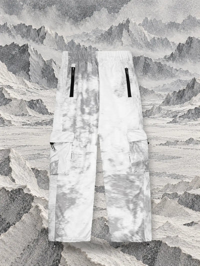 I pantaloni cargo grigi Grey Noise davanti a creste di carta velina grigia e bianca, come un ghiacciaio.