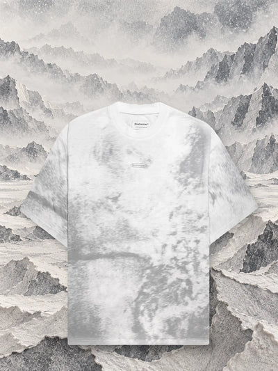 The grey Grey Noise t-shirt in front of grey and white paper ridges fading into the fog.