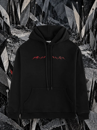 The black Insectide hoodie among blades of grey and black paper, in the night.