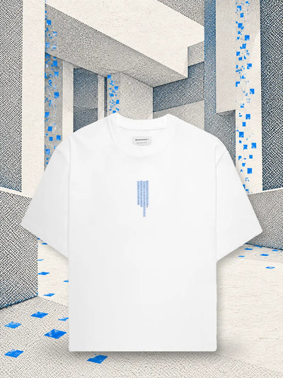 The white Litkid t-shirt in a room of white paper, where a rain of small blue paper squares falls.