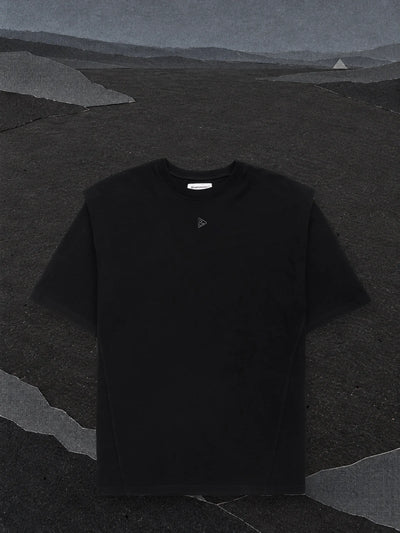 The black Minimal SP t-shirt on an almost empty plain of black paper, under a dark grey paper sky.