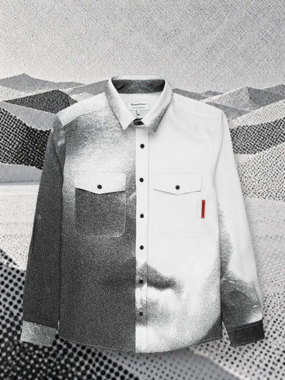 La camicia a maniche lunghe bianca e grigia Mouth sopra una piana di carta grigia stampata a retino, con colline basse sul fondo.