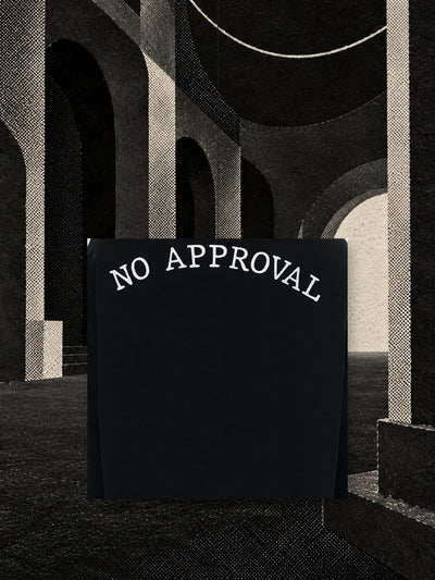 A piece of the black crewneck sweatshirt with the white embroidery on the back, hanging on a thread in a black paper hall with a pale arch.
