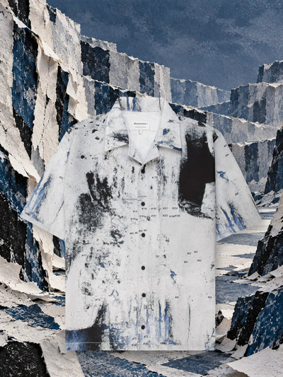 The white Rugged short sleeve shirt between walls of torn white and blue paper.