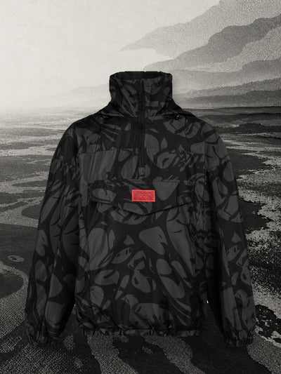 L'anorak nero Strand sulla riva di un mare di carta nera e grigia.