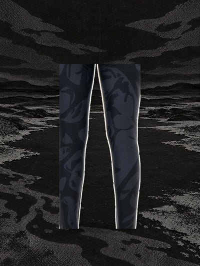 A piece of the print from the black Strand leggings, hanging on a thread above the bank of a black paper river.