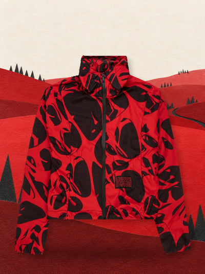 The cropped red and black Strand Red windbreaker in a valley of red paper hills.
