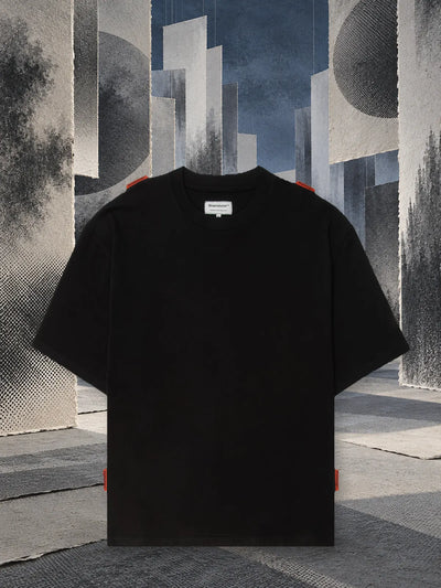 The black Stream t-shirt among hanging panels of grey paper, in the half light.