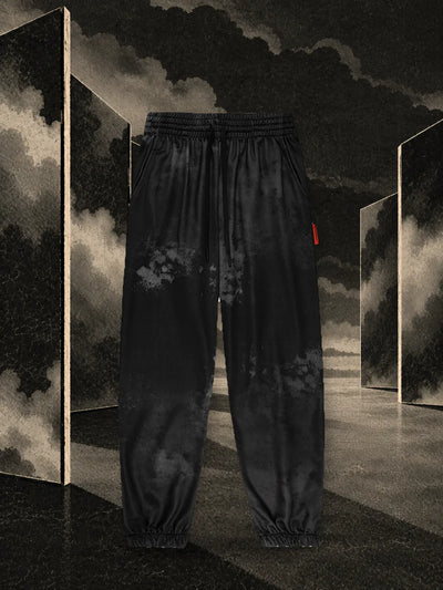 I joggers neri Triodrome fra pannelli di carta scura riflessi nell'acqua, nella nebbia.
