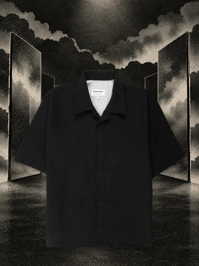 The black Triodrome short sleeve shirt among dark paper panels reflected in the water, in the fog.