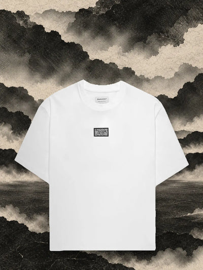 The white Triodrome t-shirt among dark paper panels, under a sky of grey paper smoke.
